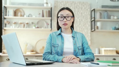 Woman Sits at Laptop in Bright Kitchen