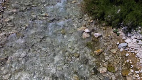 Creek water streaming on rocks, falling from mountains in spring, river texture