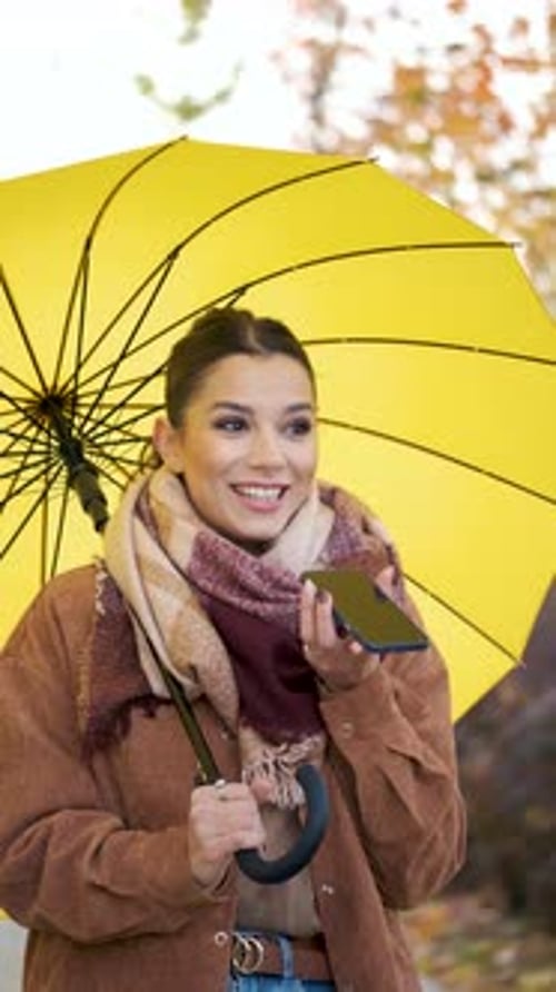Woman Talking on Phone with Umbrella in Autumn