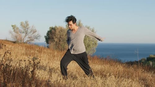 Young Man Practicing Yoga by the Ocean