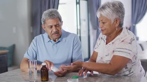 Senior Couple Discuss Medication in Home Kitchen