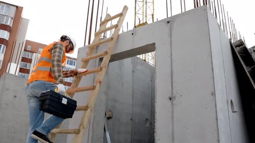 Construction Worker Climbing Ladder on Building Site