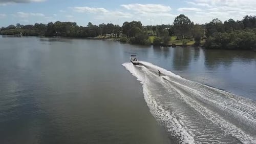 Motorboat Pulling Wakeboarder on River, Aerial Shot