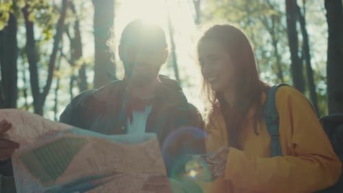Young Couple Exploring Nature with Map and Compass