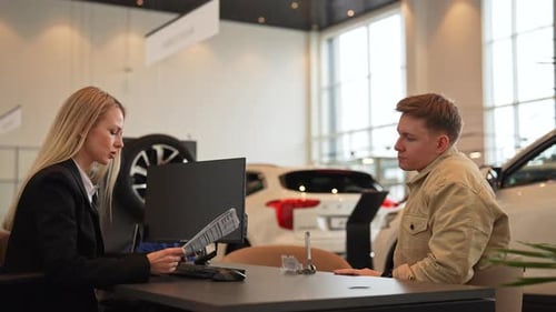 Happy Buyer Male Purchasing Automobile in Dealership Signing Paper Enjoying Successful Agreement