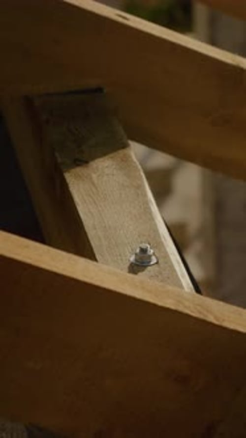 Vídeo vertical Construir una casa con vigas de madera y apretar tornillos en proceso de construcción