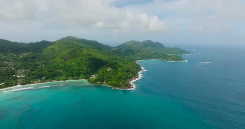 Litoral turquesa com colinas verdes que se estendem até o oceano Seychelles Mahe