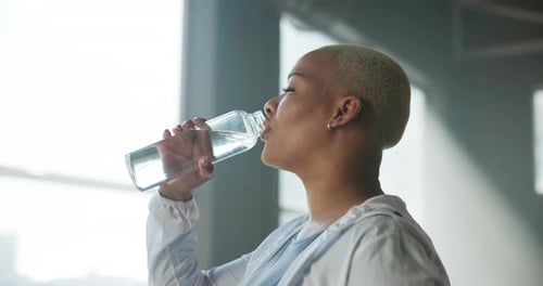Drinking water, fitness and woman in gym, wellness and hydration with break, training and fatigue