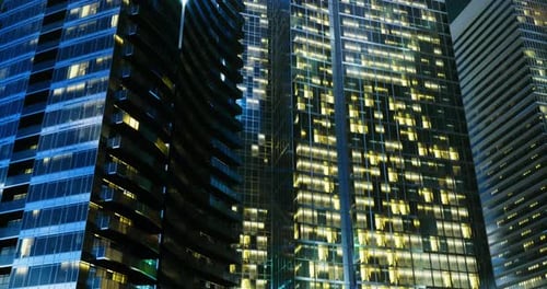 Paisagem urbana noturna exibindo arranha-céus iluminados em uma metrópole movimentada