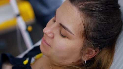 Mujer caucásica dando a luz a un bebé acostado inmóvil y sonriendo.