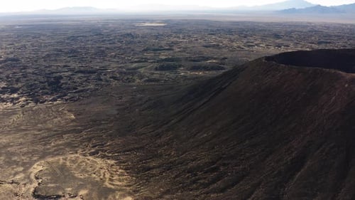 Drohnen-Nahaufnahme des Amboy-Kraters: Ein ruhender Aschenkegelvulkan erhebt sich über dem Lavafeld, geologische Gesteinsform