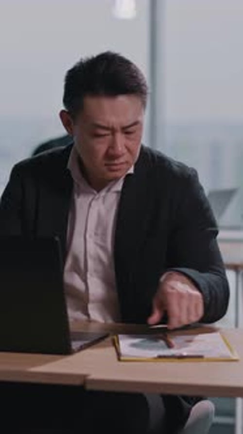 Adult Works on Laptop in Modern Office Setting