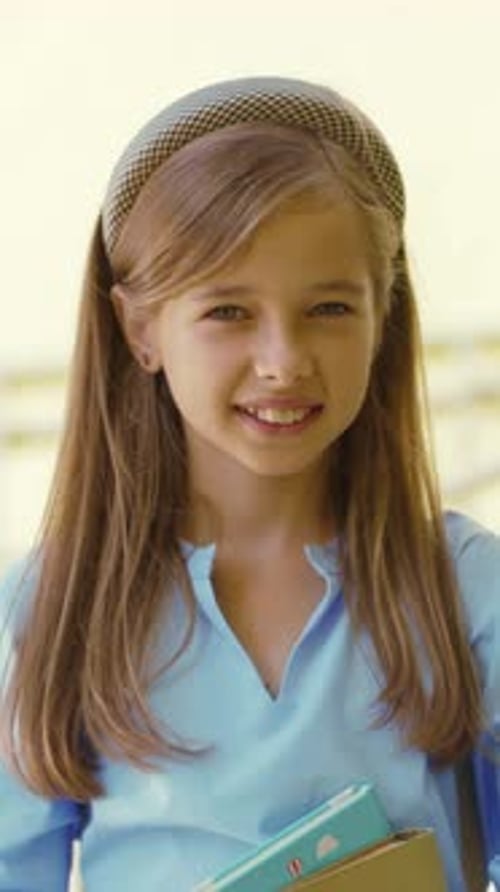 A Young Girl Who is Wearing a Stylish Headband is Holding a Book