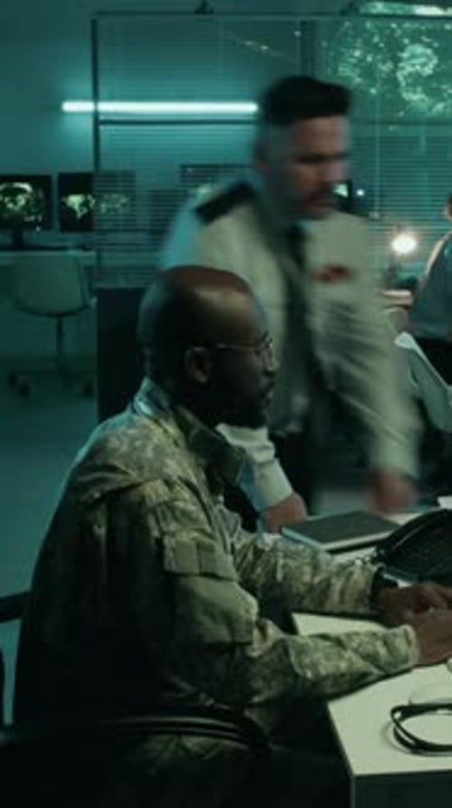 People Working at Computers in Dimly Lit Office