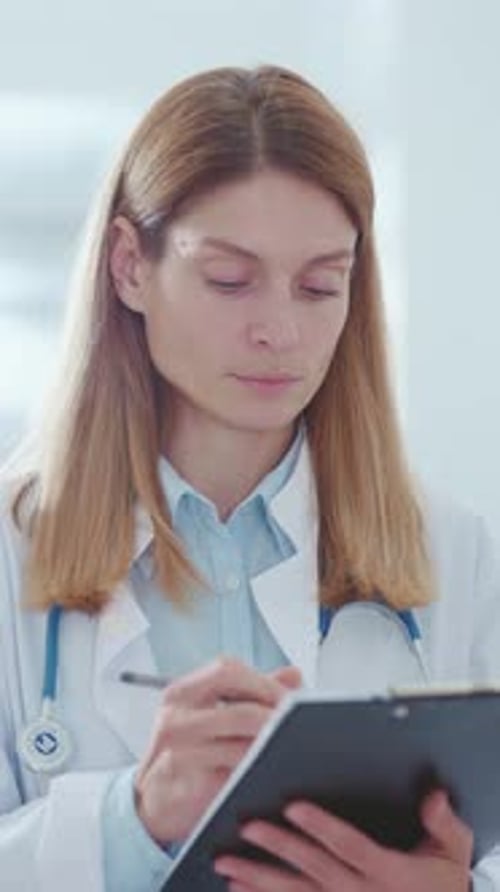 A Female Doctor Reviewing Patient Information in the Clinic to Ensure Quality Care