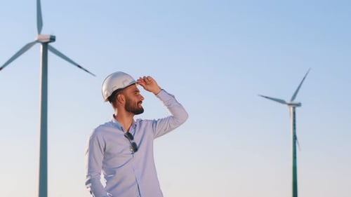 Service engineer is on the field with windmills