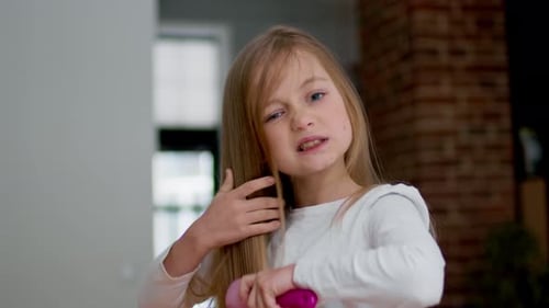 Girl Brushing Long Blonde Hair Indoors