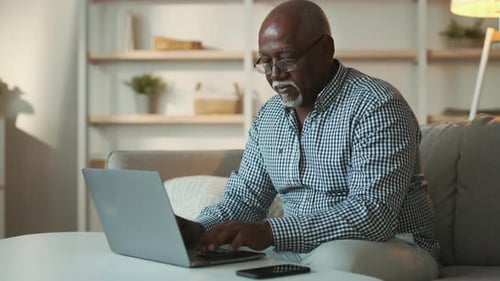 Senior Man Using Laptop in Living Room