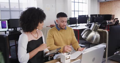 Divers collègues masculins et féminins au bureau utilisant une tablette, prenant des notes et parlant, au ralenti