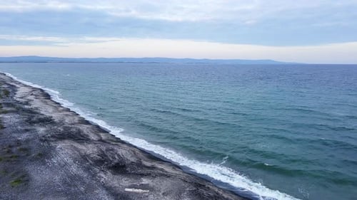 Black Sea with Waves and Turquoise Water Washing Coast Under a Cloudy Sky