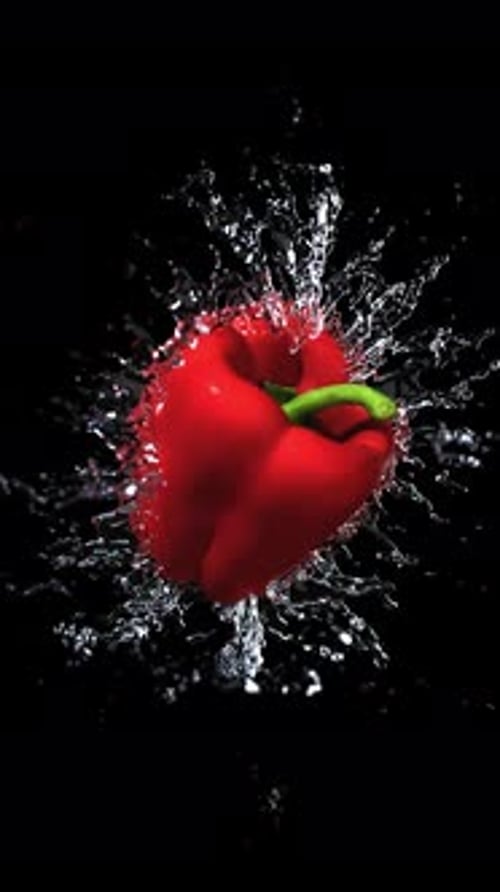 Dynamic Red Bell Pepper Splashing in Water on Black Background