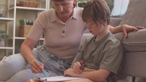 Woman Helping Young Person with Drawing at Home