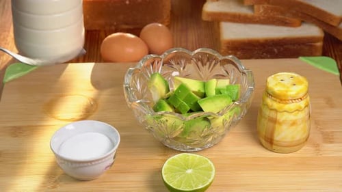 Hands Mashing Fresh Green Avocado in Glass Bowl