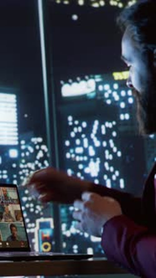 Man Leads Virtual Meeting at Night in City Office