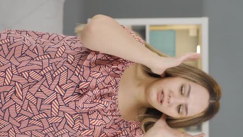 Woman smiles and touches face indoors