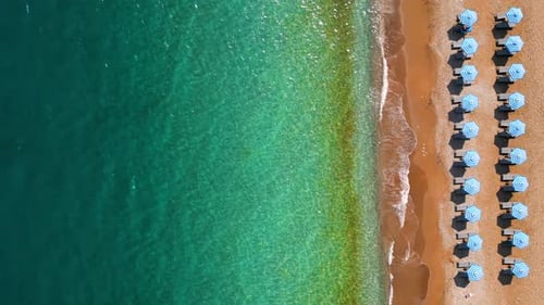 Topdown View of Sandy Beach with Sun Umbrellas and Turquoise Sea Water