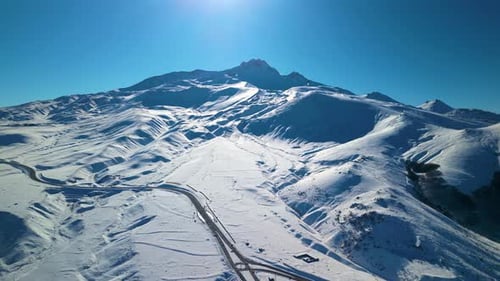 Snowy Mountain Range with Road on Winter Day