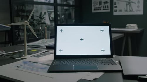 Ordinateur portable avec écran Chromakey près d'un prototype de moulin à vent sur une table de bureau