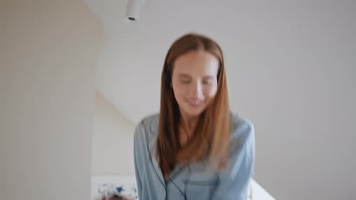 Happy Young Woman Dancing to Music at Home