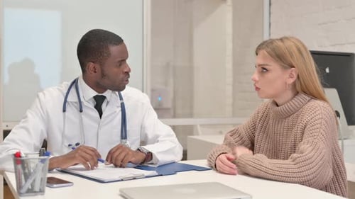 African Doctor Discussing Medical Report with Patient in Clinic