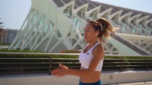 Woman Jogging Past Modern Architecture in City