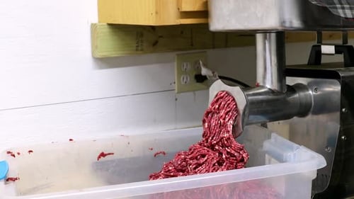 Red meat is ground in electric meat grinder