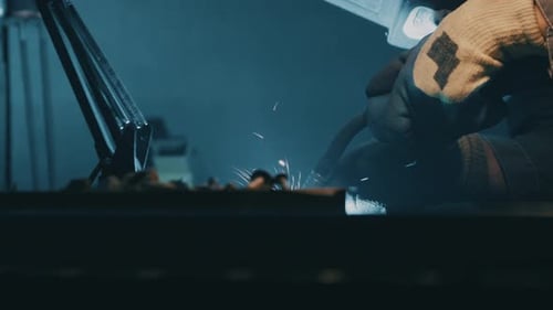 A man works with a welding machine at a factory