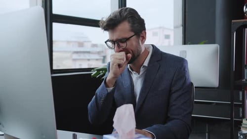 A Professional Man Diligently Working at a Modern Office Desk Equipped with a Computer