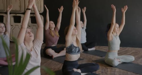 Group of Young Women in Sportswear Doing Yoga in Studio Enjoying Relaxing Exercise Together