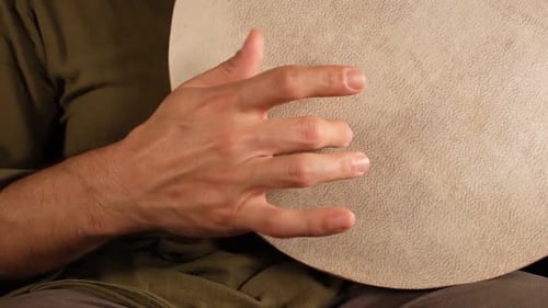 Close Up of Hand Playing Percussion Instrument