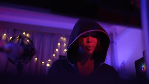 Person with Hood in the Night Time at Computer