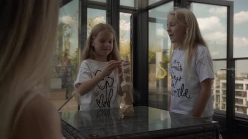 Educational Fun: Family Builds Tower with Wooden Blocks on City View Terrace