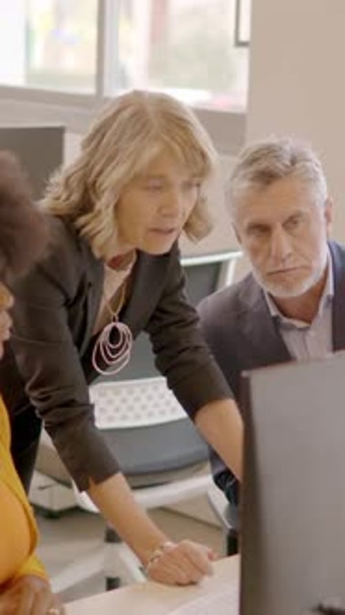 Business Team Using Computer and Discussing in a Coworking Office