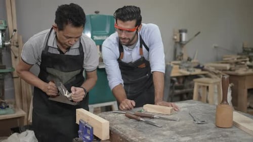 Carpenters are working together at workshop.