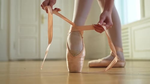 Ballerina Puts on Pointe Shoes on Leg in Dance Class Classical Ballet Dancer Woman in Dance Studio