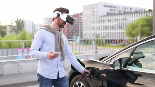 Man With VR Headset Charges Electric Car