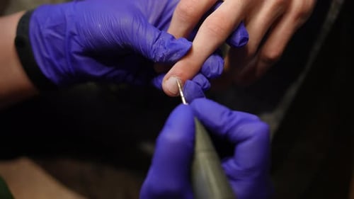 Nahaufnahme Abschneiden der Nagelhaut mit der Nagelbohrmaschine in Zeitlupe für drinnen Draufsicht Nahaufnahme männlich