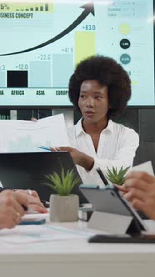 Confident Woman Presenting Business Data in Corporate Setting