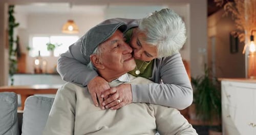 Senior couple, face and kiss in home for support, commitment and love for comfort in lounge