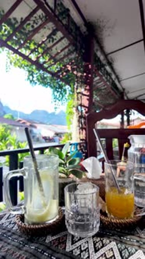 Empty drink glasses on table in Vang Vieng cafe. vertical video